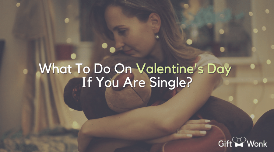 What To Do On Valentine's Day If You Are Single title image with a woman hugging a teddy bear in the background